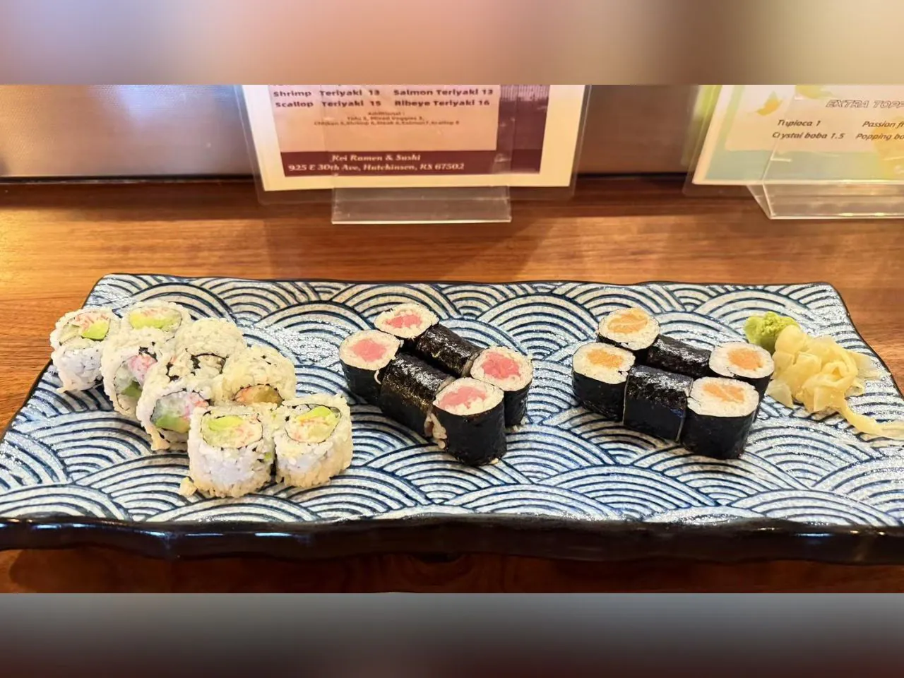 Assorted sushi rolls placed on a wave - patterned plate at Koi Ramen&Sushi, a Japanese restaurant in Hutchinson